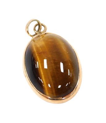 Lot 533 - An oval cabochon tiger's eye pendant, set in...