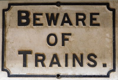 Lot 74 - A cast metal Beware of Trains sign.