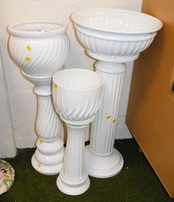 Lot 2024 - Three white glazed jardinieres and stands, the...