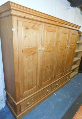 Lot 1002 - A pine wardrobe, the top with a moulded edge,...