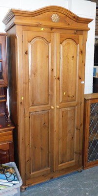 Lot 1065 - A pine double wardrobe, the interior with...