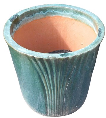Lot 654 - A terracotta green glaze cylindrical garden...