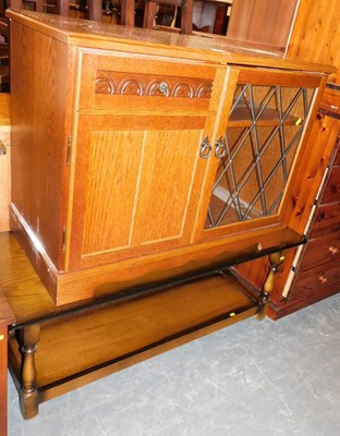 Lot 1040 - An oak music cabinet, together with an oak two-...
