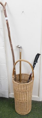 Lot 2242 - A wicker umbrella stand with three walking...