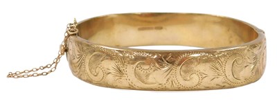 Lot 516 - A 9ct gold bangle, with engraved foliate...