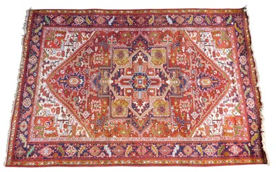 Lot 445 - A Persian Heriz carpet, red ground, with...