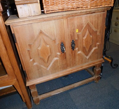 Lot 1008 - A pine side cabinet, with two carved doors,...