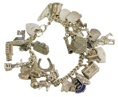 Lot 245A - A curb link charm bracelet, on a heart-shaped...