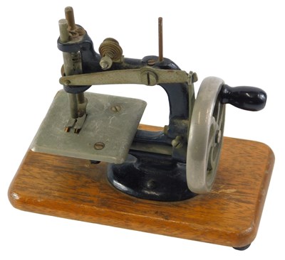 Lot 249 - A child's sewing machine, on a wooden base,...