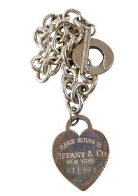 Lot 537 - A silver curb link bracelet, with claw and 'T'...