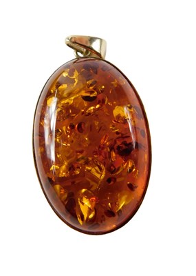 Lot 511 - A 9ct gold framed oval amber pendant, 4cm high,...