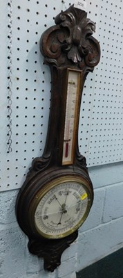 Lot 2230 - An oak cased aneroid barometer, with carved...