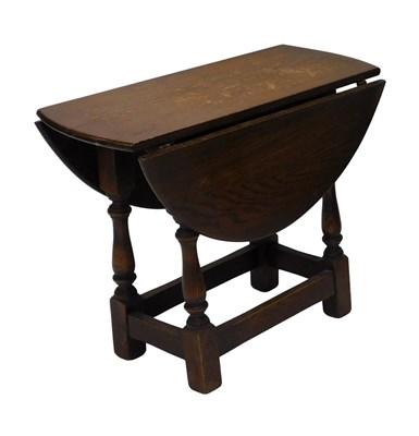 Lot 888 - A small oval oak drop leaf table, with...