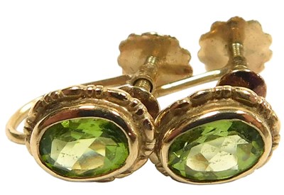 Lot 109 - A pair of peridot earrings, oval cut, in a...