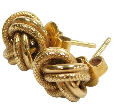 Lot 114 - A pair of knot earrings, yellow metal stamped...