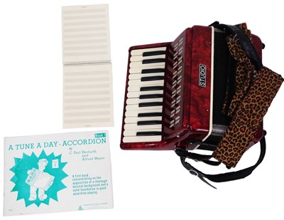 Lot 144 - A Studio bass accordion, in a red marbled...
