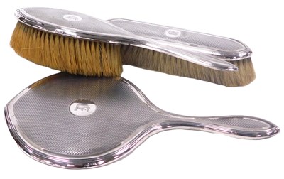 Lot 400 - A George V silver backed three piece dressing...