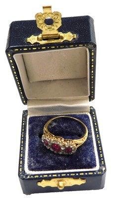 Lot 410 - A ruby three stone flower head ring, each ruby...
