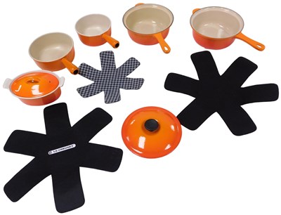 Lot 445 - Four Le Creuset orange enamel saucepans,...