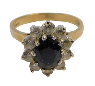 Lot 246 - A 9ct gold cluster ring, set with an oval cut...
