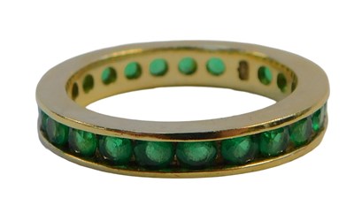 Lot 245 - An 18ct gold emerald eternity band, set with...