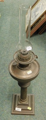 Lot 2004 - A metal oil lamp, with glass chimney.