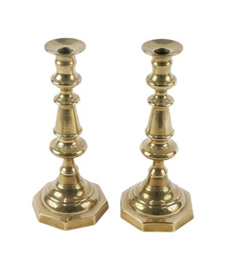 Lot 150 - A pair of late 19thC brass candlesticks, on an...