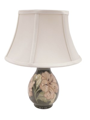 Lot 487 - A Moorcroft table lamp, on a green ground with...
