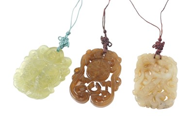 Lot 562 - Three carved jade pendants, comprising green...