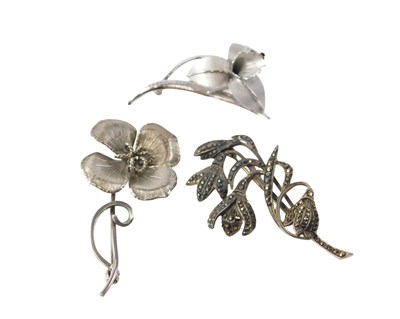 Lot 558 - Three floral brooches, to include a marcasite...