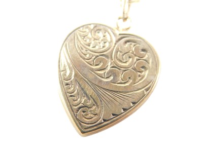 Lot 554 - A 9ct gold heart shaped pendant on curb link...
