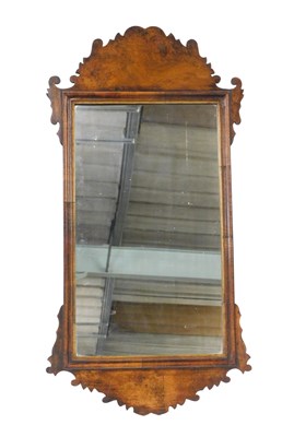 Lot 822 - A walnut fret framed wall mirror, with shaped...