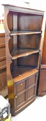 Lot 1517 - An Ercol dark elm corner unit, with three...