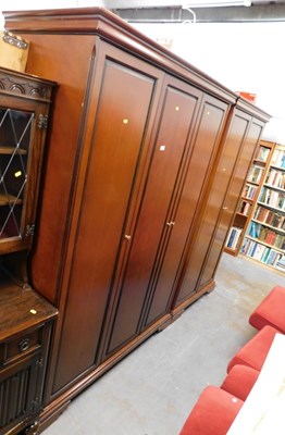 Lot 1694 - A dark wood triple wardrobe, with brass...