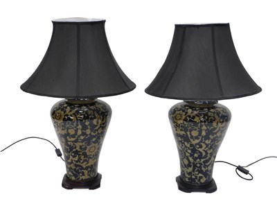 Lot 1062 - A pair of ceramic table lamps, each decorated...
