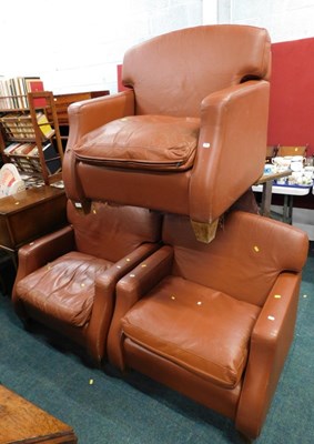 Lot 1710 - Three brown leather armchairs, each with a...