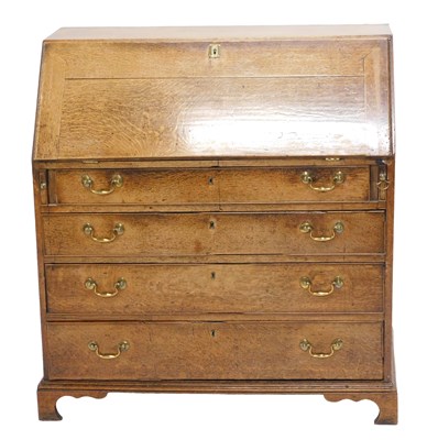 Lot 1045 - A George III oak bureau, the fall enclosing a...