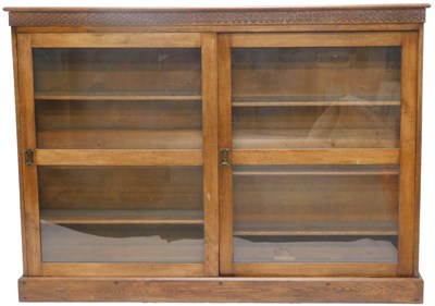 Lot 1049 - An early 20thC oak bookcase, with a blind fret...