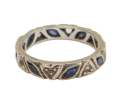 Lot 57 - An eternity ring, set with blue and white...