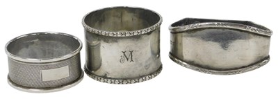 Lot 245 - Three silver napkin rings, one with engine...