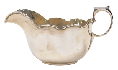 Lot 247 - A George VI silver sauce boat, with a pie...