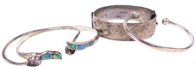 Lot 349 - A silver bangle, with foliate engraved...