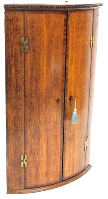 Lot 558 - A Geogian oak bow front hanging corner...