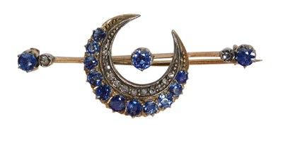 Lot 433 - A crescent moon brooch, set with blue and...