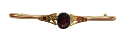 Lot 236 - A bar brooch, the oval garnet in a rub over...
