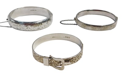 Lot 631 - Three silver bangles, each of differing design,...