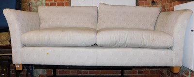 Lot 1012 - A two-seater sofa upholstered in cream floral...