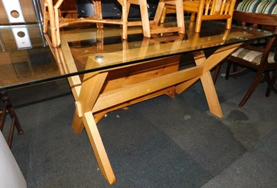 Lot 1040 - A glass topped dining table, on a wooden...